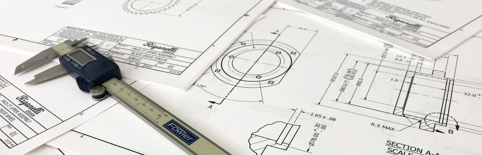 Professional manufacturing drawings with digital caliper on a drafting table